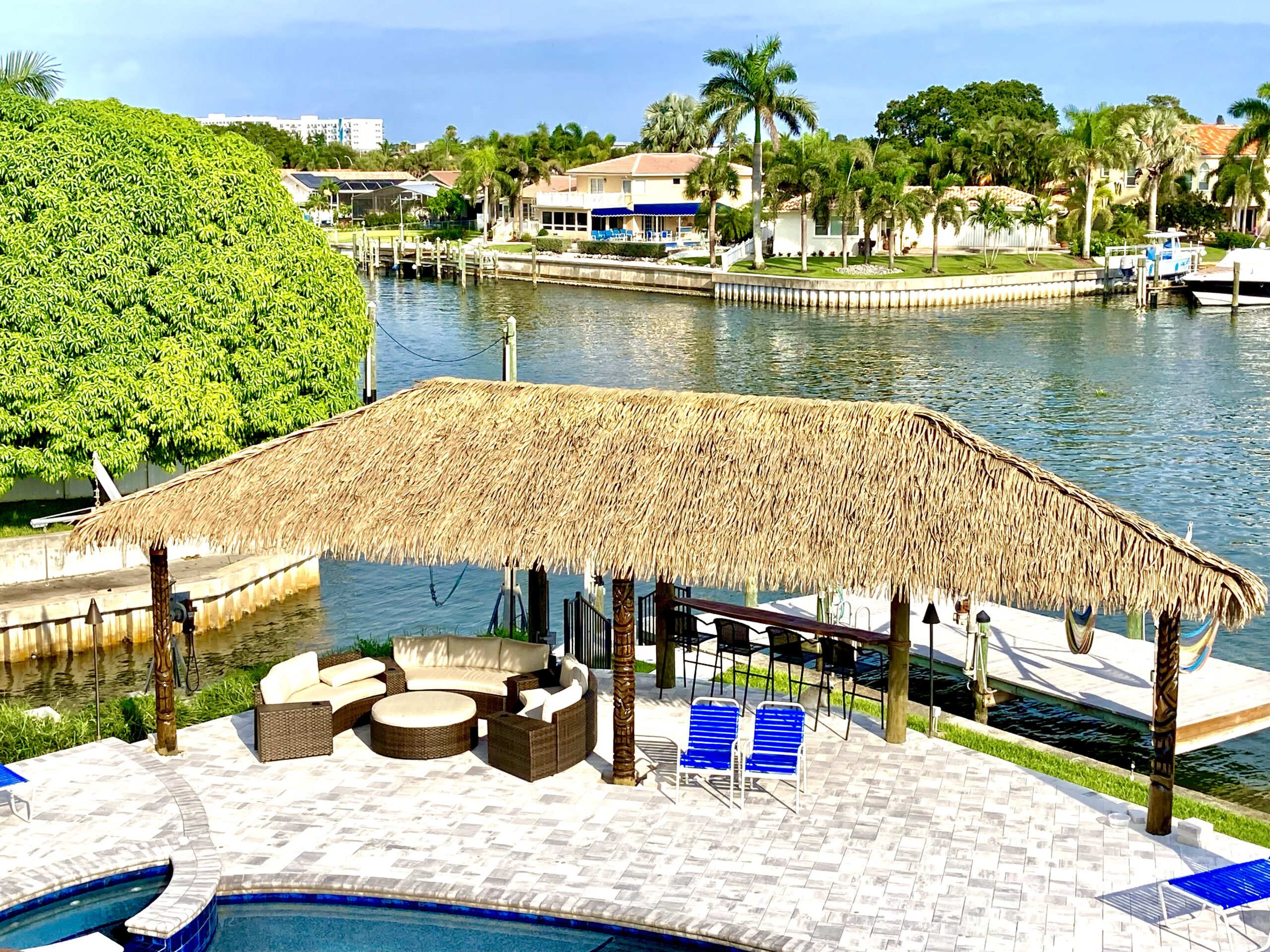 Canal‑Side Tiki Hut with Palm Thatch Roof & Seating